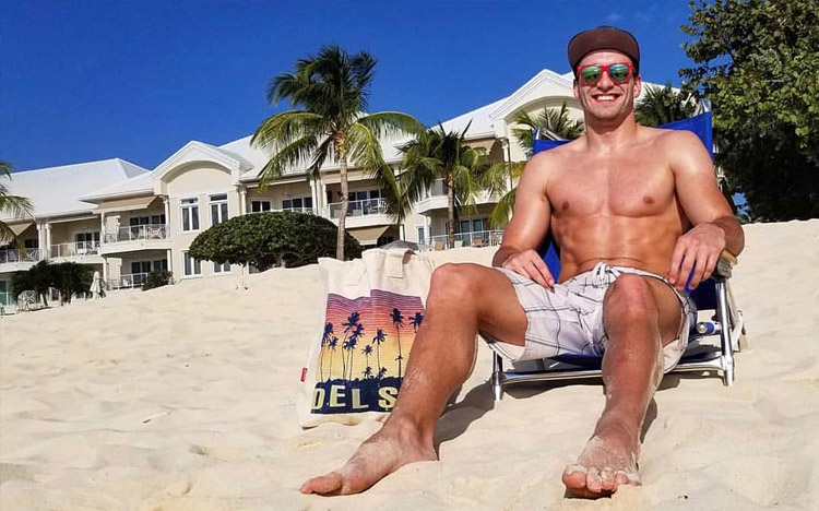 guy sitting on the beach with a Del Sol tote bag